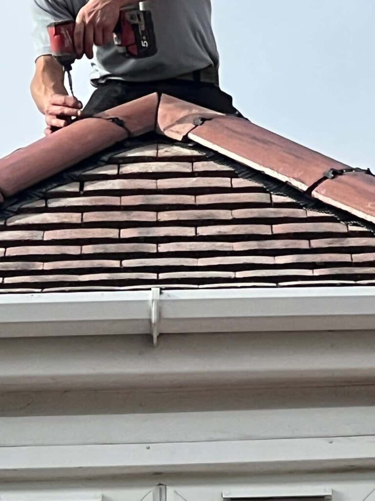 This is a photo of one of the operatives of West Bridgford Roofing Repairs installing new ridge tiles