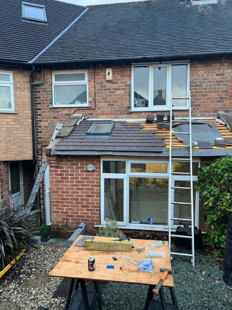 This is a photo of a roof extension that is having new roof tiles installed. This is a photo taken from the roof ridge looking down a tiled pitched roof on to a flat roof. Works carried out by West Bridgford Roofing Repairs